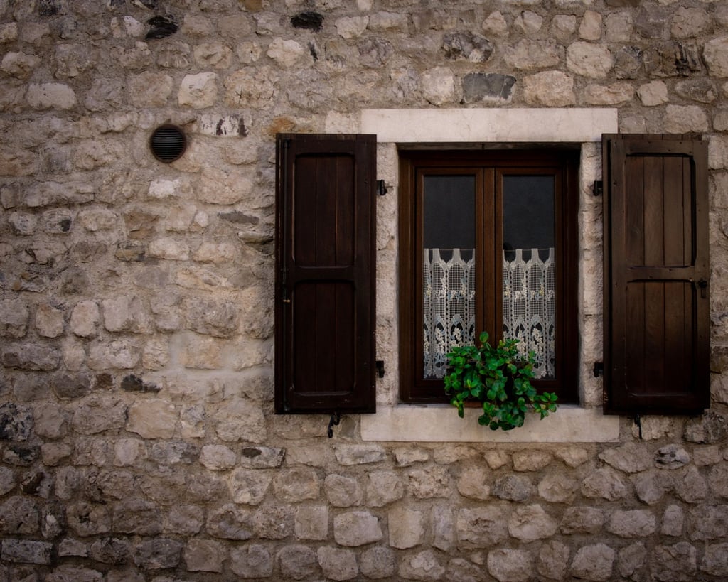 Fenster mit Holzläden in Steinmauer