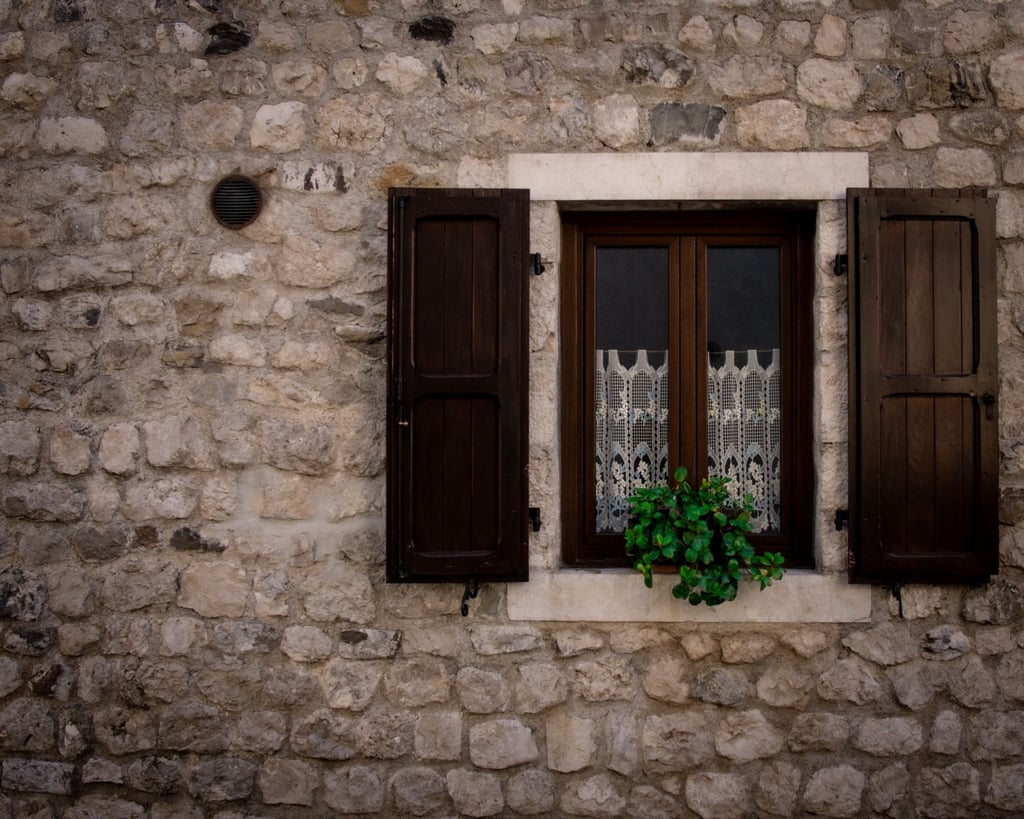 Fenster mit Holzläden in Steinmauer
